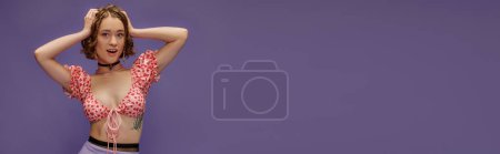 Téléchargez les photos : Excité jeune femme en haut recadré avec des cœurs regardant caméra sur fond violet, bannière - en image libre de droit