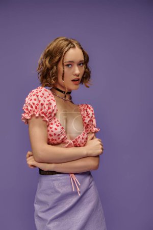 Foto de Atractiva mujer joven en la parte superior recortada con corazones y falda posando sobre fondo púrpura, juventud - Imagen libre de derechos