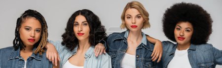 Photo for Group portrait of stylish multiethnic girlfriends in blue denim clothes on grey, horizontal banner - Royalty Free Image
