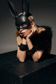 vertical shot of dreamy hot woman in sexy lingerie posing near cube with rabbit mask and handcuffs puzzle #679261780