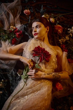weibliche Eleganz, brünette und romantische Frau in transparentem Kleid zwischen schönen Blumen liegend