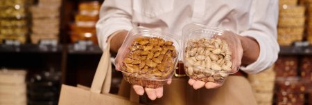 Photo for Cropped view of mature woman posing with almonds and pistachios in hands at grocery store, banner - Royalty Free Image