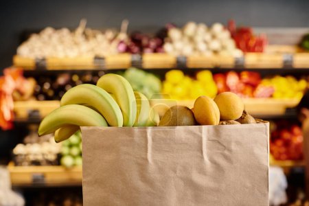 Objektfoto einer Einkaufstasche voller frischer, natürlicher Früchte mit verschwommenem Lebensmittelstand vor dem Hintergrund