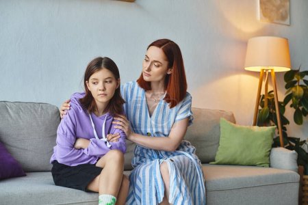 fürsorgliche Mutter beruhigt aufgebrachte Teenager-Tochter sitzt auf Couch im Wohnzimmer, Pflege und Unterstützung