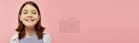 retrato de chica adolescente despreocupada y feliz con sonrisa radiante mirando a la cámara en rosa, pancarta