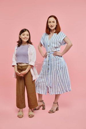 Photo for Full length of cheerful and stylish woman with preteen daughter posing and looking at camera on pink - Royalty Free Image
