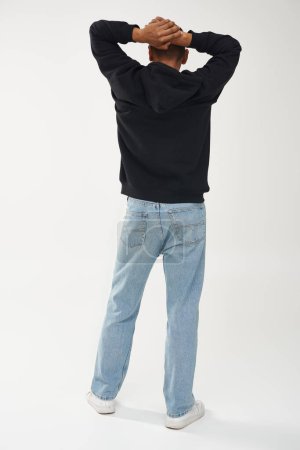 Téléchargez les photos : Modèle masculin afro-américain tendance en sweat à capuche et jeans noirs décontractés, espace de copie pour la publicité - en image libre de droit