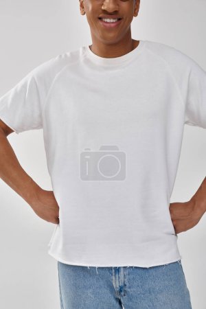 stylish african american man in trendy casual jeans and white t-shirt, copy space for advertising