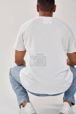 hombre afroamericano con estilo en jeans casual de moda y camiseta blanca, espacio de copia para la publicidad