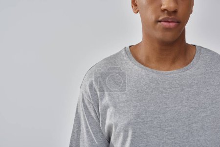 hombre afroamericano joven de moda que usa la camiseta gris casual, espacio de copia para la publicidad