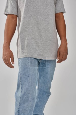 stylish african american man in trendy casual jeans and gray t-shirt, copy space for advertising