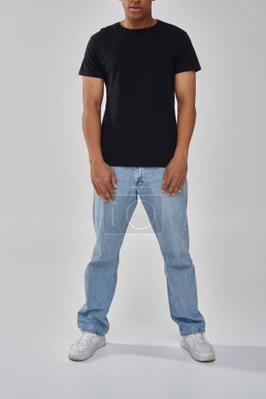 stylish african american male model posing in black t-shirt and jeans, copy space for advertising
