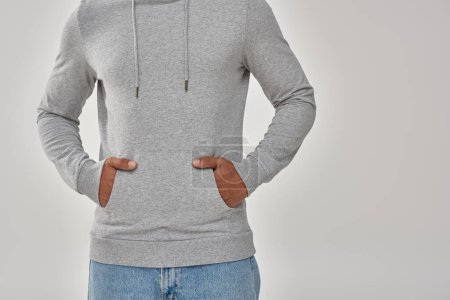 hombre afroamericano con estilo en sudadera casual gris y jeans, espacio de copia para la publicidad