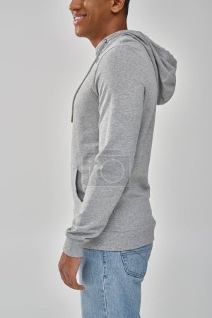 stylischer afrikanisch-amerikanischer Mann in grauem lässigem Sweatshirt und Jeans, Kopierraum für Werbung