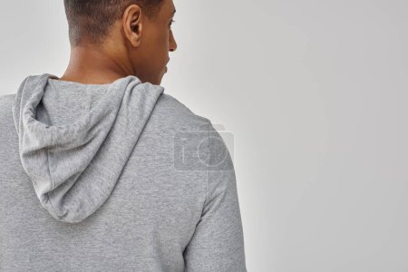 elegant african american man in casual sweatshirt on white background, copy space for advertising