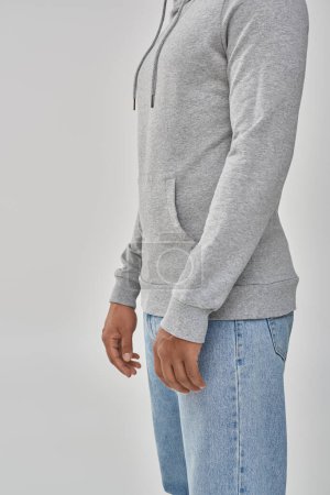 stylish african american man in gray casual sweatshirt and jeans, copy space for advertising