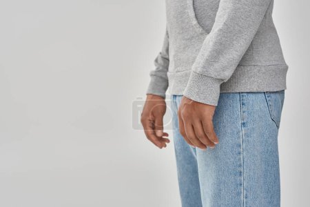hombre afroamericano con estilo en sudadera casual gris y jeans, espacio de copia para la publicidad