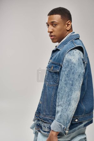good looking african american man in stylish denim outfit posing in motion, fashion concept