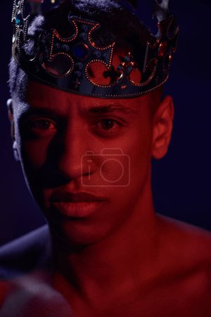 Photo for Portrait of sexy shirtless african american man in golden crown posing in lights, fashion concept - Royalty Free Image