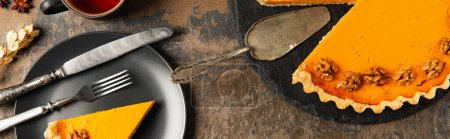Erntedank-Stillleben, Kürbiskuchen neben schwarzem Teller und Vintage-Besteck auf Steinoberfläche, Banner