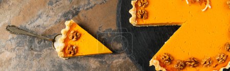 Foto de Espátula de pastel con delicioso pastel de acción de gracias decorado con nueces en la superficie de piedra, pancarta - Imagen libre de derechos