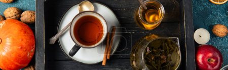 wooden tray with herbal tea and aromatic honey near autumnal items, thanksgiving concept, banner
