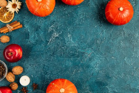 Téléchargez les photos : Thanksgiving toile de fond avec des citrouilles, des noix et des objets automnaux colorés sur la surface texturée bleue - en image libre de droit