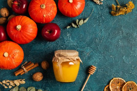 thanksgiving theme, pumpkins near jar of honey and fall harvest objects on blue textured surface