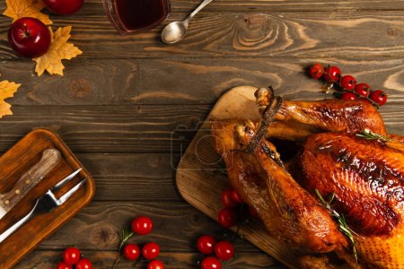 Photo for Thanksgiving still life, grilled turkey near maple syrup and cherry tomatoes on rustic wooden table - Royalty Free Image
