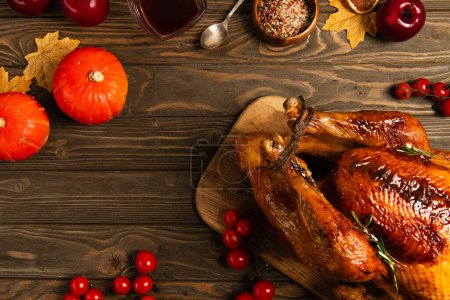 Thanksgiving toile de fond, dinde grillée près de citrouilles et épices sur table en bois avec décor automnal