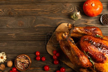 Photo for Grilled turkey and freshly baked buns near spices and cherry tomatoes on wooden table, thanksgiving - Royalty Free Image