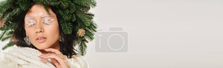 Photo for Winter beauty banner, beautiful woman with green wreath posing with knitted scarf on grey backdrop - Royalty Free Image