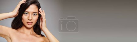 banner of asian woman with sparkling green eye makeup and bare shoulders posing on grey background