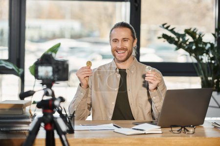 heureux homme d'affaires ambitieux montrant Bitcoins et enregistrement vidéo blog sur appareil photo numérique au bureau