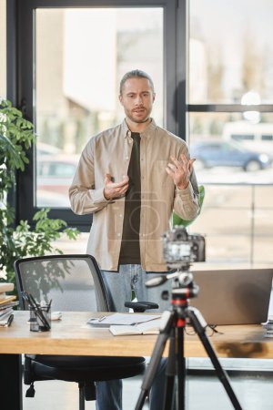 kreativer Geschäftsmann spricht vor der Digitalkamera während Videoblog im Büro, Marketing