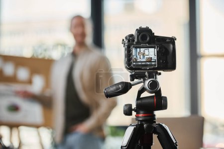 Selektiver Fokus auf Digitalkameras in der Nähe verschwommener Geschäftsleute, die Videoblog im modernen Büro aufzeichnen