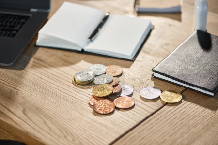 Gold- und Silberbitcoins in der Nähe von Notizbüchern auf dem Schreibtisch im modernen Büro, virtuelle Kryptowährung
