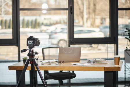 Professionelle Digitalkamera in Schreibtischnähe mit Laptop und Dokumenten im modernen Büro