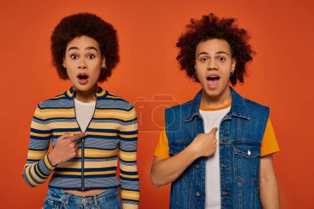 shocked young african american siblings in casual outfits looking surprised, family concept