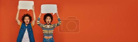 shocked african american brother and sister posing with speech bubbles on orange backdrop, banner