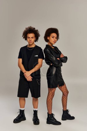attractive trendy african american siblings in fashionable black outfits posing actively together
