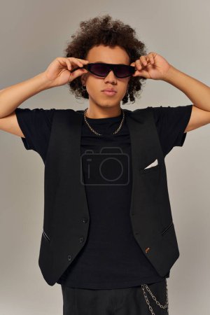 Foto de Guapo afroamericano de moda en traje de moda con gafas de sol elegantes posando en la cámara - Imagen libre de derechos