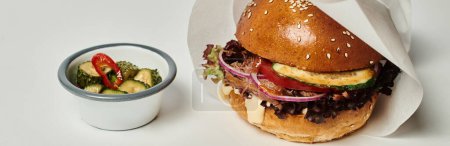 Téléchargez les photos : Bannière de hamburger avec pain de sésame, bœuf et cornichons comme plat d'accompagnement sur plateau en bois sur fond gris - en image libre de droit