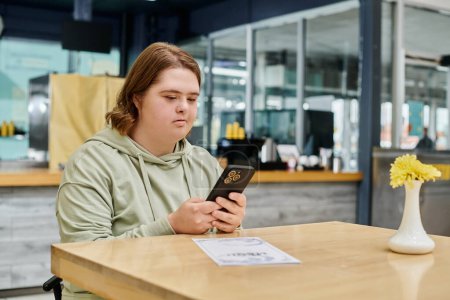 mujer joven con mensajes de trastorno mental en el teléfono móvil cerca de la tarjeta de menú en la mesa en la cafetería