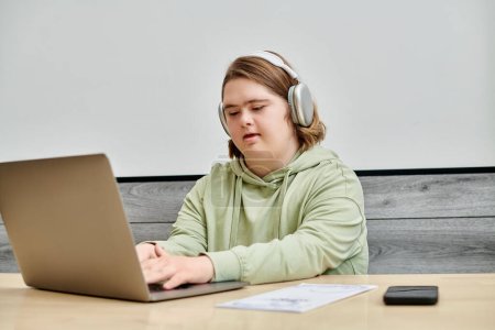 mujer joven con síndrome de Down en la red de auriculares inalámbricos en el portátil en la mesa en la cafetería moderna