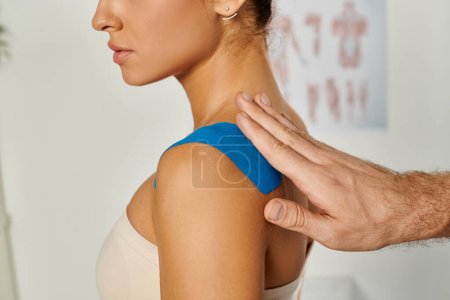 Photo for Cropped view of doctor putting kinesiological tape on his female young patient, healthcare - Royalty Free Image
