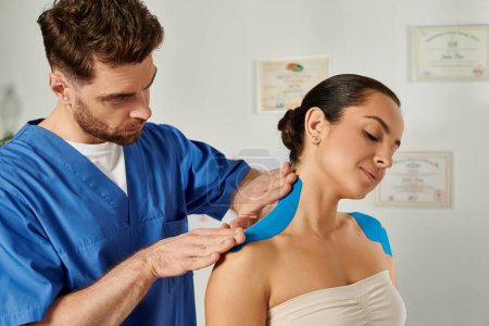 Foto de Guapo médico poniendo cinta cinesiológica en el cuello de su paciente durante la cita, atención médica - Imagen libre de derechos
