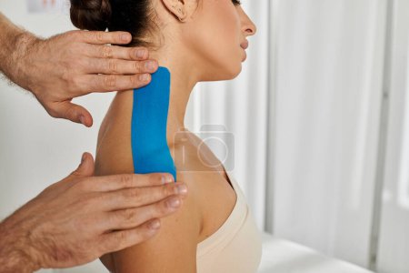 Foto de Vista recortada del médico poniendo cintas de kinesio en su paciente femenino durante la cita, atención médica - Imagen libre de derechos