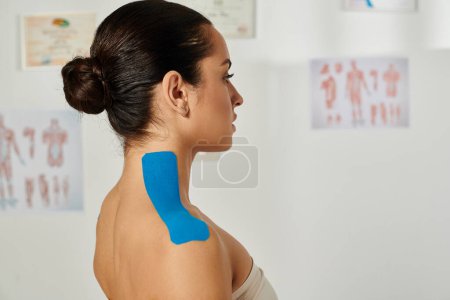 beautiful young patient with kinesiological tapes on her body posing in profile, healthcare