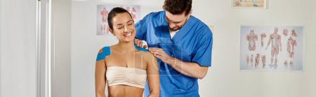 Photo for Joyous attractive woman sitting while her handsome doctor putting kinesio tapes on her body, banner - Royalty Free Image